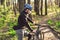Young man ride mountain bike in forest. Young athletic man riding a bicycle in park. Male cyclist wearing face respirator, with