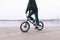 Young man rides a BMX bike on the waterfront near the river. Walk on BMX