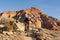 A young man rides a mountain bike over a sandstone ledge on the Jem trail in the desert of Southern Utah