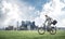 Young man riding bicycle on green grass