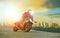 young man riding big motorcycle leaning on sharp curve with urban building background