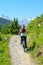 Young man riding bike up to the hill in beautiful Swiss Alps, close to famous Zermatt. Mountain ridges with snow on tops in