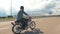 Young man riding custom motorcycle on street road, slow motion. Motorciclist ride his hand made custom bike