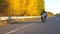 Young man riding fast on modern sport motorbike at autumnal highway. Motorcyclist racing his motorcycle on country road