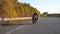 Young man riding fast on modern sport motorbike at autumnal highway. Motorcyclist racing his motorcycle on country road