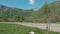 Young man riding longboard on country road on summer day outdoors.