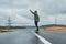 Young man riding a longboard on empty winding mountain road in summer, rear view.