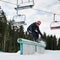 Young man riding snowboard at ski resort.