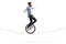 Young man riding a unicycle on a rope and balancing with hands