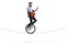 Young man riding a unicycle on a rope and playing an acoustic guitar