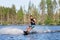 Young man riding wakeboard on summer lake