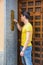 Young man ringing doorbell and talking on speaker