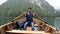 Young man rowing in boat on mountain lake