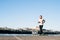 Young man running around the harbor and listening to music with a pair of headphones