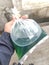 a young man\'s hand holds a plastic filled with vehicle fuel oil