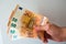 Young man`s hand paying with some bank notes of fifty euros