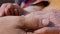 A young man`s hands comforting an elderly pair of hands of grandmother outdoor close-up.Sun comes out from behind the