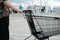 young man`s hands holding shopping cart outdoors