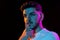 Young man's portrait on black studio background in neon light. Concept of human emotions, facial expression, youth
