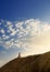 Young man in sand desert in sundown silhouette