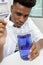 Young man scientist using auto-pipette with flask in laboratory