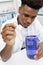Young man scientist using auto-pipette with flask in medical laboratory