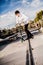 Young man with scooter making a Grind on Skatepark