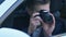 Young man secretly taking photo sitting in car, spying detective, journalist