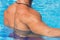 Young man With Sexy Body In Swimwear around Swimming Pool Water At Relax Spa Resort. Fitness Model With Skin Sun Tan Relaxing On