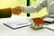 Young man shaking hands with real estate agents in the office and A close-up house plan above the dealer offers a list of home pri