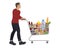 Young man with shopping cart full of food and drinks
