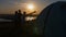 Young man showing friends beautiful view through telescope at summer sunset