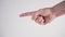 A young man shows with his hand and fingers the direction sign to the left on a white background