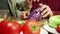 A young man is shredding a cabbage for a salat and talking