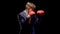 A young man in a simple blue suit and a white shirt with Boxing gloves to prepare for the confrontation