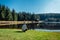 Young man sit on nice clean pond with wooden building and spring tree with blue sky