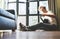 Young man sits on the floor at home and tunes the guitar