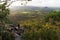 A young man sits, quietly meditating on top of a mountain with expansive views near Noosa Heads, Australia.