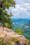 Young man sits on rock at Dragon Crest or Khuan Sai at Khao Ngon Nak Nature Trail in Krabi, Thailand