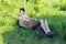 A young man sits in a rusty wheelbarrow in the garden on a sunny day