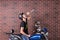 Young man sitting on a bike drinking alcohol