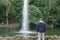 young man sitting contemplating a lake water fountain