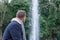 young man sitting contemplating a lake water fountain