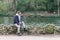 young man sitting contemplating the water of a lake