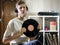 Young man sitting in cozy living room holding the vinyl record disk near records rack on the floor