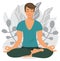 A young man is sitting cross-legged, doing yoga and enjoying meditation. A person gets rid of stress. Yoga at home or