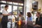 Young man sitting with friends ordering food to waitress