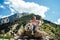 Young man sitting on hill. Dreamy male sitting on altitude and looking at Peaks of magnificent rocks located against