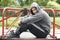 Young Man Sitting In Playground