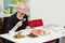 Young man sitting at sushi bar, smiling